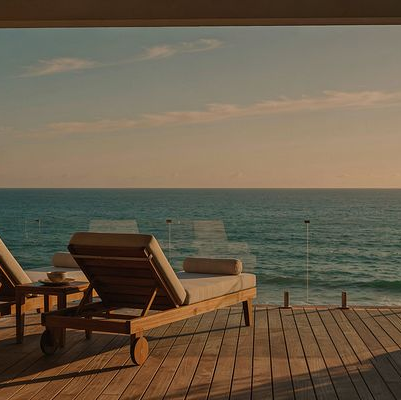 Terraza de madera con tumbonas frente al mar